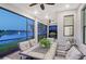 Covered patio with seating, overlooking the lake, ceiling fan, and outdoor dining set at 5187 Barnett Cir, Bradenton, FL 34211