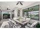 Covered patio with ample seating, scenic lake view, ceiling fans, and an outdoor kitchen area at 5187 Barnett Cir, Lakewood Ranch, FL 34211