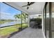 Screened patio featuring lake view, ceiling fan, grill, and brick flooring, perfect for outdoor cooking at 5187 Barnett Cir, Lakewood Ranch, FL 34211