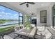 Inviting patio with lake view, outdoor dining set, and ceiling fans, ideal for entertaining guests at 5187 Barnett Cir, Lakewood Ranch, FL 34211