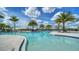 Community pool surrounded by palm trees with lounge chairs and sun canopies on a bright day at 5187 Barnett Cir, Lakewood Ranch, FL 34211
