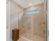 Modern walk-in shower features floor-to-ceiling tile, a built-in bench, and a frameless glass door at 5187 Barnett Cir, Lakewood Ranch, FL 34211