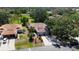 An aerial view of a well-maintained single-story home with lush landscaping and a spacious driveway at 5192 Cedar Hammock Ln, Sarasota, FL 34232