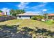 Back of home showing spacious yard, mature trees, and a well-maintained exterior at 5192 Cedar Hammock Ln, Sarasota, FL 34232