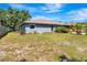 Rear view of a well-kept home with a spacious backyard, tidy landscaping, and inviting outdoor space at 5192 Cedar Hammock Ln, Sarasota, FL 34232