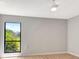 Cozy bedroom with neutral walls, a ceiling fan, and a window offering natural light and greenery at 5192 Cedar Hammock Ln, Sarasota, FL 34232