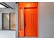 Close up view of an orange front door, complimented by light gray walls, and side window at 5192 Cedar Hammock Ln, Sarasota, FL 34232