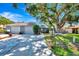 Charming single-story home featuring a spacious two-car garage and a lush, mature tree in the front yard at 5192 Cedar Hammock Ln, Sarasota, FL 34232