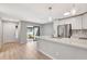 Bright kitchen features white cabinets, stainless steel appliances, breakfast bar, and access to outdoor area at 5192 Cedar Hammock Ln, Sarasota, FL 34232