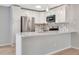 Kitchen featuring white cabinets, stainless steel appliances, backsplash, and breakfast bar with pendant lights at 5192 Cedar Hammock Ln, Sarasota, FL 34232