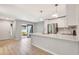Bright kitchen features white cabinets, stainless steel appliances, breakfast bar, and access to outdoor area at 5192 Cedar Hammock Ln, Sarasota, FL 34232