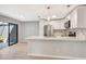 A bright kitchen featuring modern stainless steel appliances, a kitchen island, and a sliding glass door at 5192 Cedar Hammock Ln, Sarasota, FL 34232
