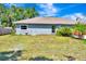 Side view of a cozy home featuring fresh exterior paint, lush landscaping, and manicured flower beds at 5192 Cedar Hammock Ln, Sarasota, FL 34232