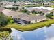 Aerial view of a house with screened in lanai with pool and backyard pond at 5240 Bentgrass Way, Bradenton, FL 34211