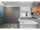 Bright bathroom featuring a glass-enclosed shower, soaking tub, and stylish gray tiling and cabinets at 5240 Bentgrass Way, Bradenton, FL 34211