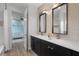 Modern bathroom with dual sinks, black cabinets, and a doorway view to a Bedroom with a crib at 5240 Bentgrass Way, Bradenton, FL 34211