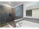 Bathroom featuring a glass-enclosed shower, soaking tub, and stylish gray tiling at 5240 Bentgrass Way, Bradenton, FL 34211