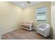 Cozy Bedroom room with wood-like ceramic tile, white chair, and crib at 5240 Bentgrass Way, Bradenton, FL 34211