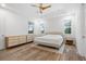 Spacious bedroom with tray ceiling, wood-look floors, and bright natural light at 5240 Bentgrass Way, Bradenton, FL 34211