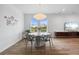 Stylish dining room with a round marble table, modern lighting fixture, and views of the lake at 5240 Bentgrass Way, Bradenton, FL 34211