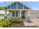 Inviting home entrance with stone accents, blue shingle siding, and charming front porch landscaping at 5240 Bentgrass Way, Bradenton, FL 34211