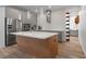 Spacious kitchen with stainless steel appliances, gray cabinetry, wood island, and decorative lighting at 5240 Bentgrass Way, Bradenton, FL 34211