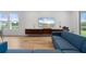 Bright living room featuring modern furniture, wood-look tile floors, and large windows overlooking a pond at 5240 Bentgrass Way, Bradenton, FL 34211