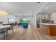 Open living space with modern decor, a bright blue sofa, and access to the kitchen with stainless appliances at 5240 Bentgrass Way, Bradenton, FL 34211