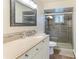 A bathroom with granite counters and a large mirror and glass enclosed shower at 5329 Ansonia Ter, North Port, FL 34287