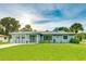 Charming single-story home with a well-manicured lawn, attached garage, and beautiful blue exterior paint at 5329 Ansonia Ter, North Port, FL 34287