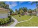 Well-manicured front yard showcasing lush lawn, mature trees and stone walkway at 5356 Royal Palm Ave # 5356, Sarasota, FL 34234