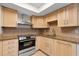 Stylish kitchen featuring granite countertops, stainless steel appliances, and light wood cabinets under a skylight at 5356 Royal Palm Ave # 5356, Sarasota, FL 34234