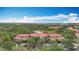 Aerial view of a condominium complex with beautiful trees, a pond, and a blue sky at 5459 Bentgrass Dr # 2-116, Sarasota, FL 34235