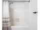 Clean bathroom with a shower, white tiled wall, shower curtain, and towel rack at 5459 Bentgrass Dr # 2-116, Sarasota, FL 34235