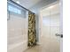Bathroom boasting a white tiled shower/tub combination and decorative tropical print shower curtain at 5459 Bentgrass Dr # 2-116, Sarasota, FL 34235