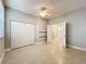 Bedroom with tile floors, neutral walls, double door closet and view of hallway staircase at 5459 Bentgrass Dr # 2-116, Sarasota, FL 34235