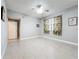 Bright bedroom with neutral walls, ceiling fan, tile floors, and a window with tropical print curtains at 5459 Bentgrass Dr # 2-116, Sarasota, FL 34235