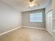 Neutral bedroom showcasing tile floors, a window, ceiling fan, and a spacious closet at 5459 Bentgrass Dr # 2-116, Sarasota, FL 34235