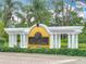 Las Palmas Luxury Condominiums entrance sign with palm trees, green bushes, and white decorative columns at 5459 Bentgrass Dr # 2-116, Sarasota, FL 34235