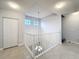 Hallway with a staircase view, white railing, tiled floors, and modern lighting at 5459 Bentgrass Dr # 2-116, Sarasota, FL 34235