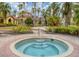 Inviting community hot tub with brick-paved surround and lush tropical landscaping at 5459 Bentgrass Dr # 2-116, Sarasota, FL 34235