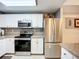 Modern kitchen featuring stainless steel appliances, granite counters, and white cabinets at 5459 Bentgrass Dr # 2-116, Sarasota, FL 34235