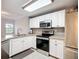 Bright kitchen with granite countertops, stainless steel appliances and white cabinets at 5459 Bentgrass Dr # 2-116, Sarasota, FL 34235