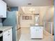 Kitchen with stainless steel appliances, white cabinetry, and island, flowing into dining area at 5459 Bentgrass Dr # 2-116, Sarasota, FL 34235