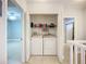 Hallway laundry area features a front-loading washer and dryer set neatly stored with shelves above at 5459 Bentgrass Dr # 2-116, Sarasota, FL 34235