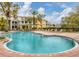 Resort-style swimming pool with lounge chairs surrounded by tropical landscaping and condos at 5459 Bentgrass Dr # 2-116, Sarasota, FL 34235