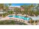 Resort pool at Las Palmas with lounge chairs and palm trees at 5459 Bentgrass Dr # 2-116, Sarasota, FL 34235