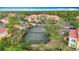 Overhead view of a community tennis court surrounded by lush landscaping and condominium buildings at 5459 Bentgrass Dr # 2-116, Sarasota, FL 34235