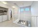 Bright upstairs landing with a chandelier and a laundry closet at 5459 Bentgrass Dr # 2-116, Sarasota, FL 34235