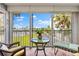 Inviting screened balcony with tile flooring, comfortable seating, and views of the pool and landscaping at 5600 Beach Way Dr # 201, Sarasota, FL 34242